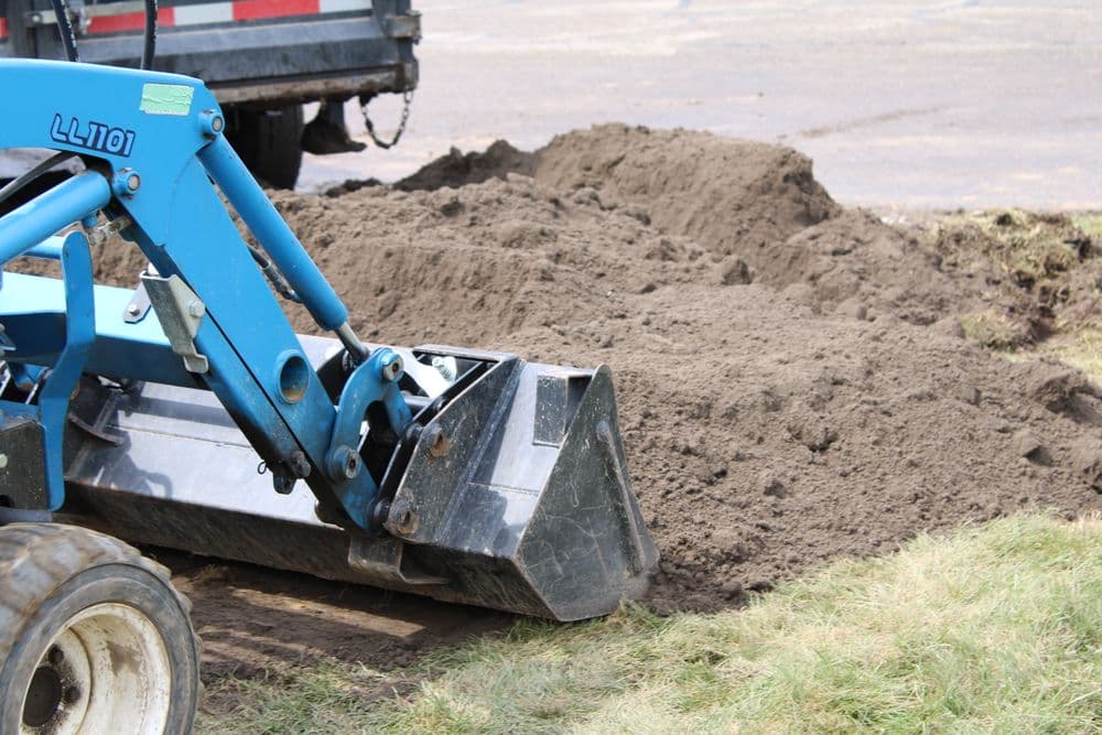 Backhoe loader working on soil excavation at a construction site. Heavy machinery in action.