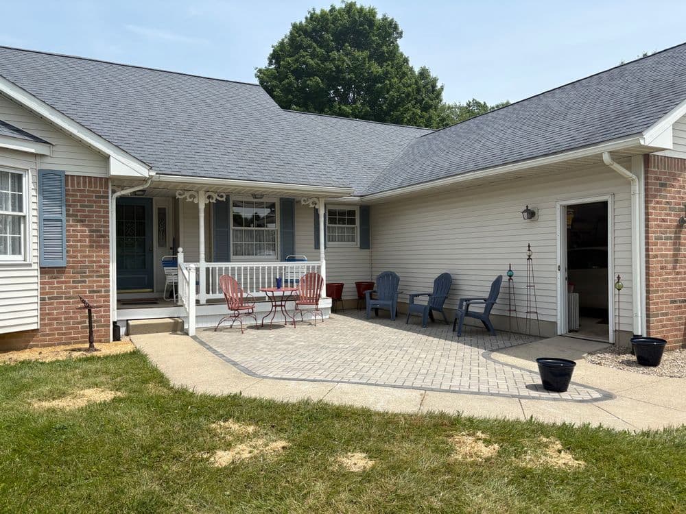 Cozy home exterior with patio, seating area, and landscaped garden. Perfect for outdoor relaxation.